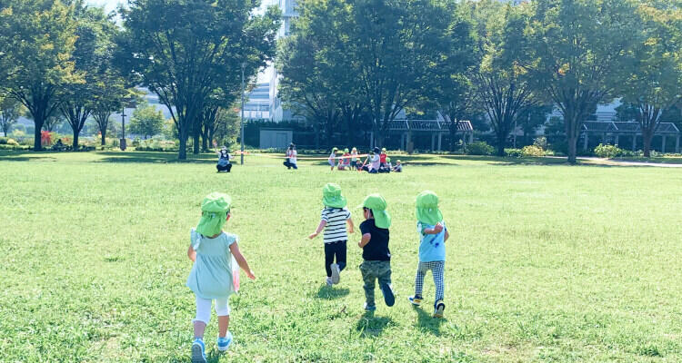 芝生で遊んでいる園児たちの写真