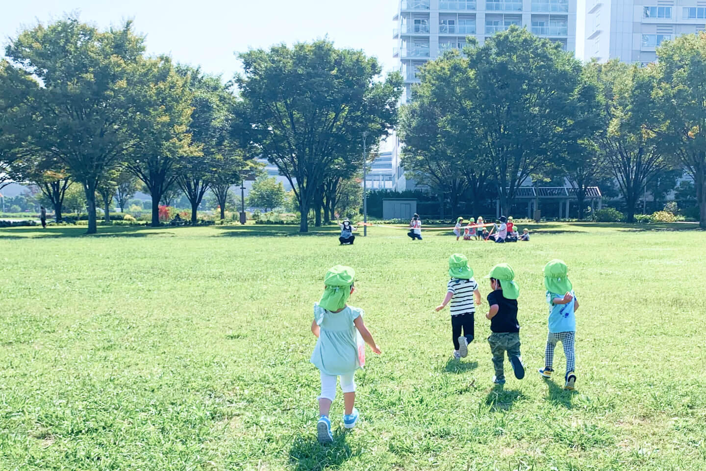 芝生で園児たちが走っている写真